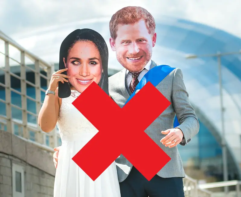 Meghan Markle and Prince Harry with a large Red X