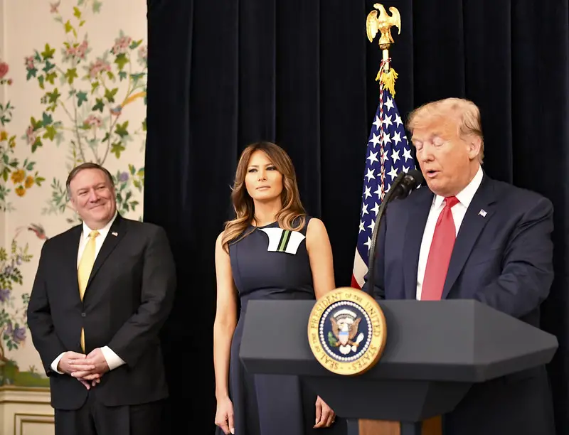 Trump speaking by a podium with First Lady Melania and Mike Pompeo