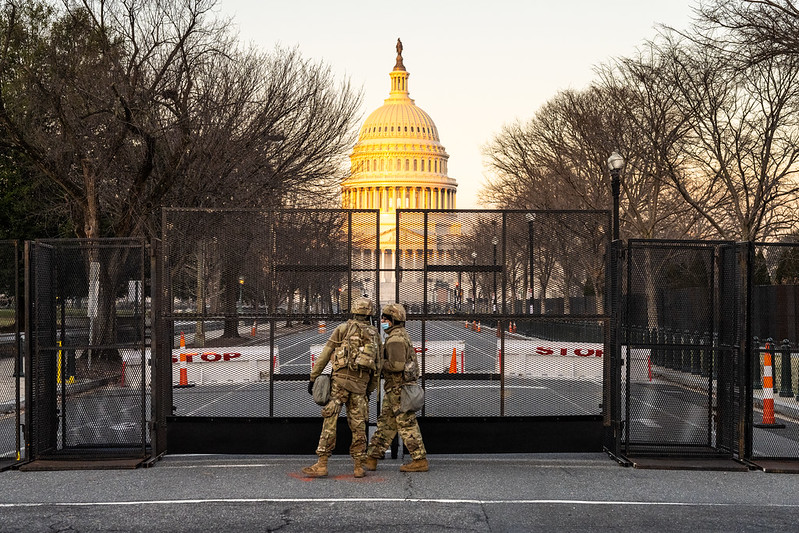 Us Capital Building behind fence and military personnel