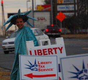 Liberty Tax Service sign with Woman in Lady Liberty costume